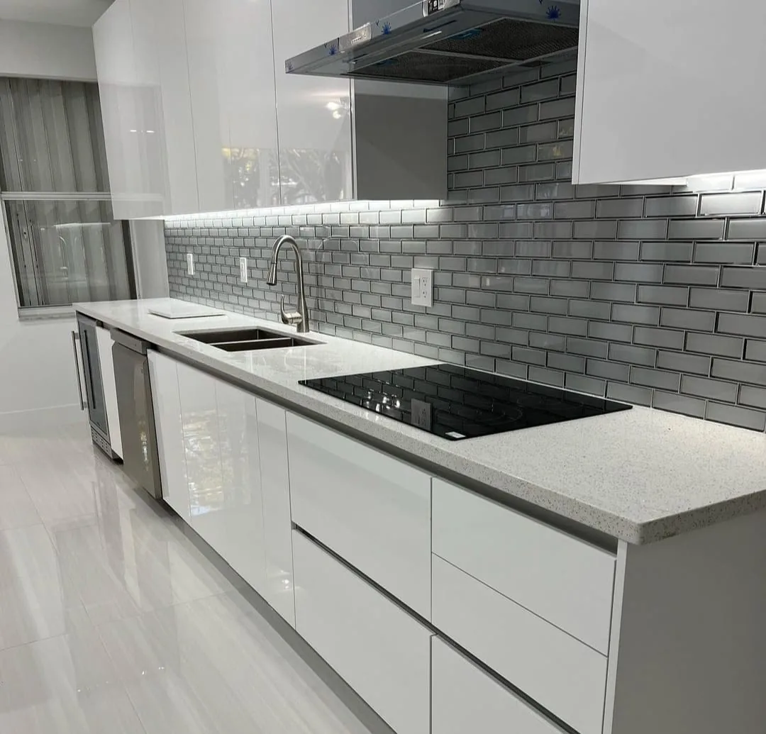 White kitchen remodel with gray subway tile backsplash and quartz counters