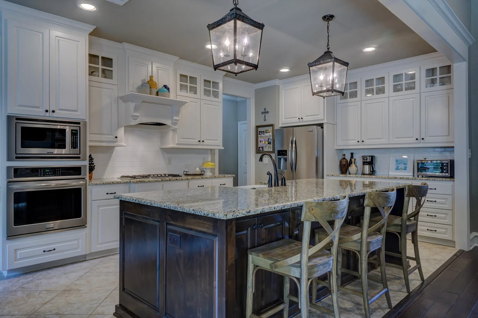 Custom white kitchen with dark island and pendant lighting