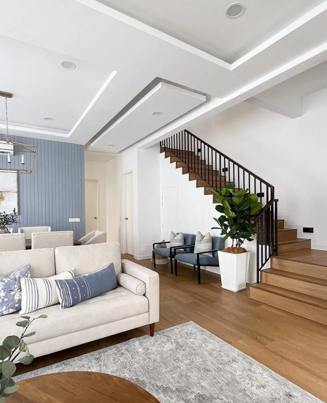 Open living room renovation with wood flooring and custom staircase