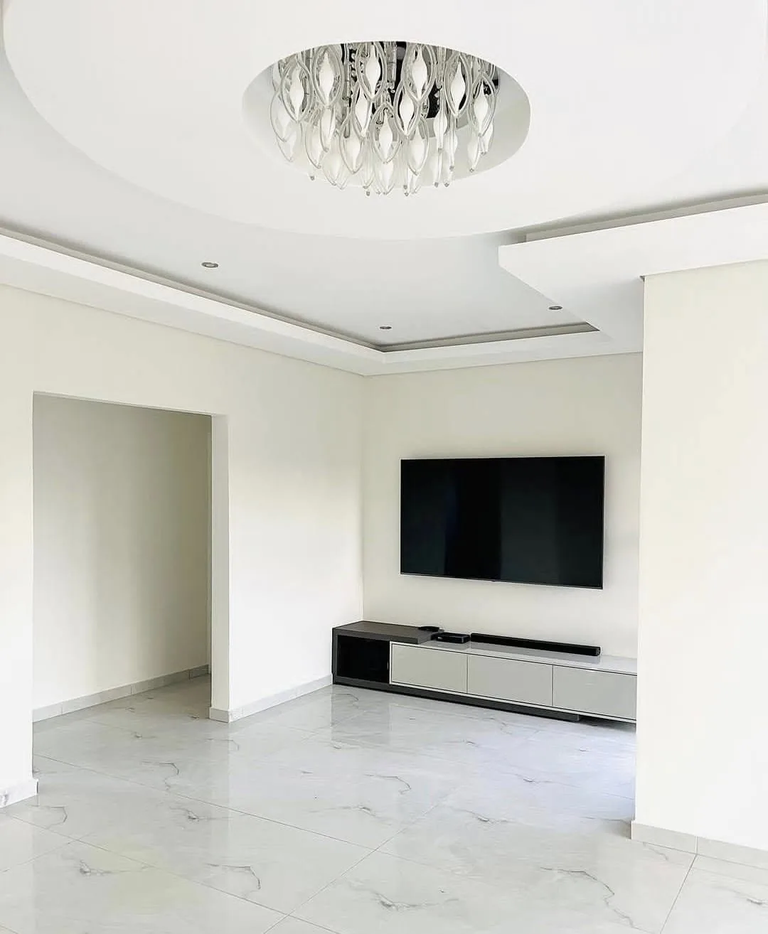 Interior living room renovation with tile floor and detailed ceiling work